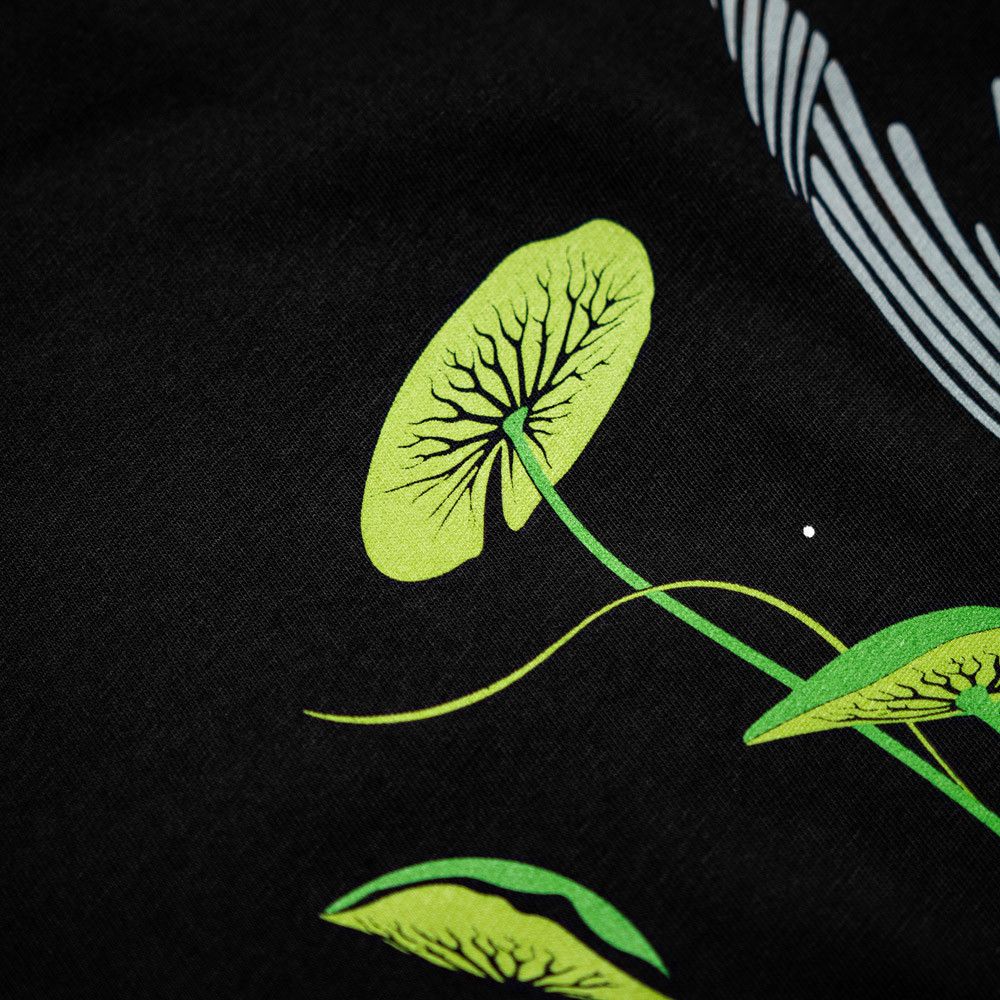 Kumu Camiseta Tails Up Está inspirado en uno de los momentos más fascinantes : una carpa alimentándose entre lirios, rodeada de burbujas.